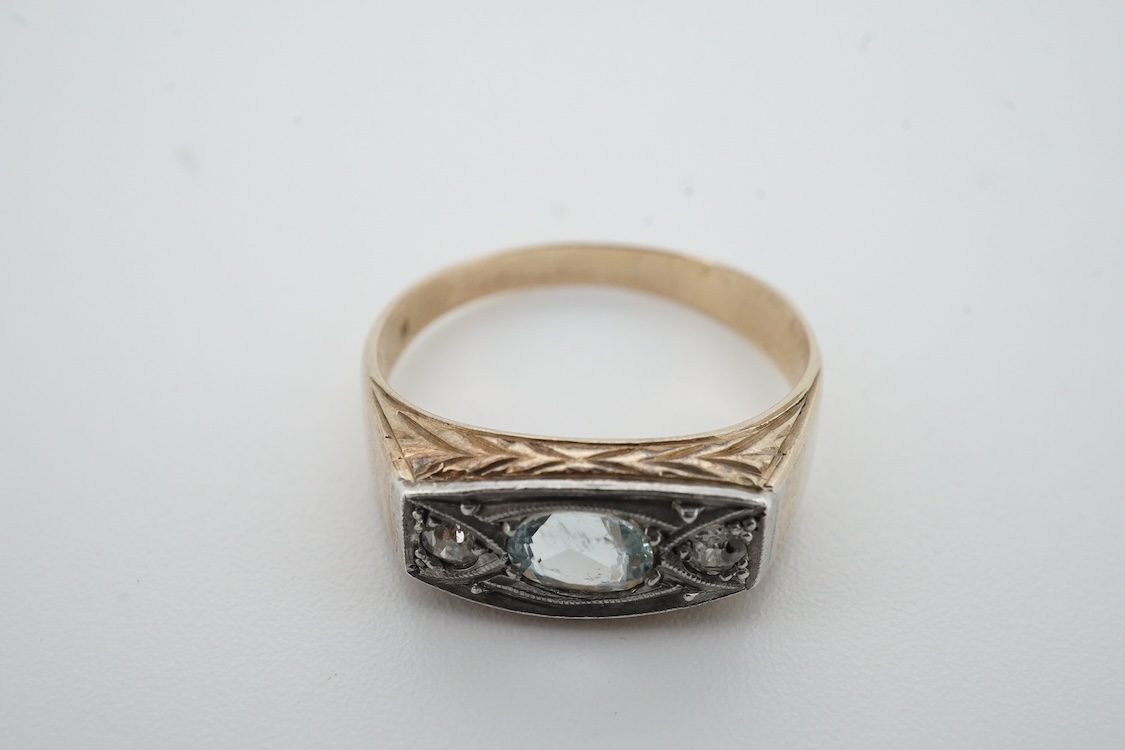 A mid 20th century yellow metal (stamped 585), aquamarine and diamond set three stone ring, size 0, gross weight 4.6 grams.